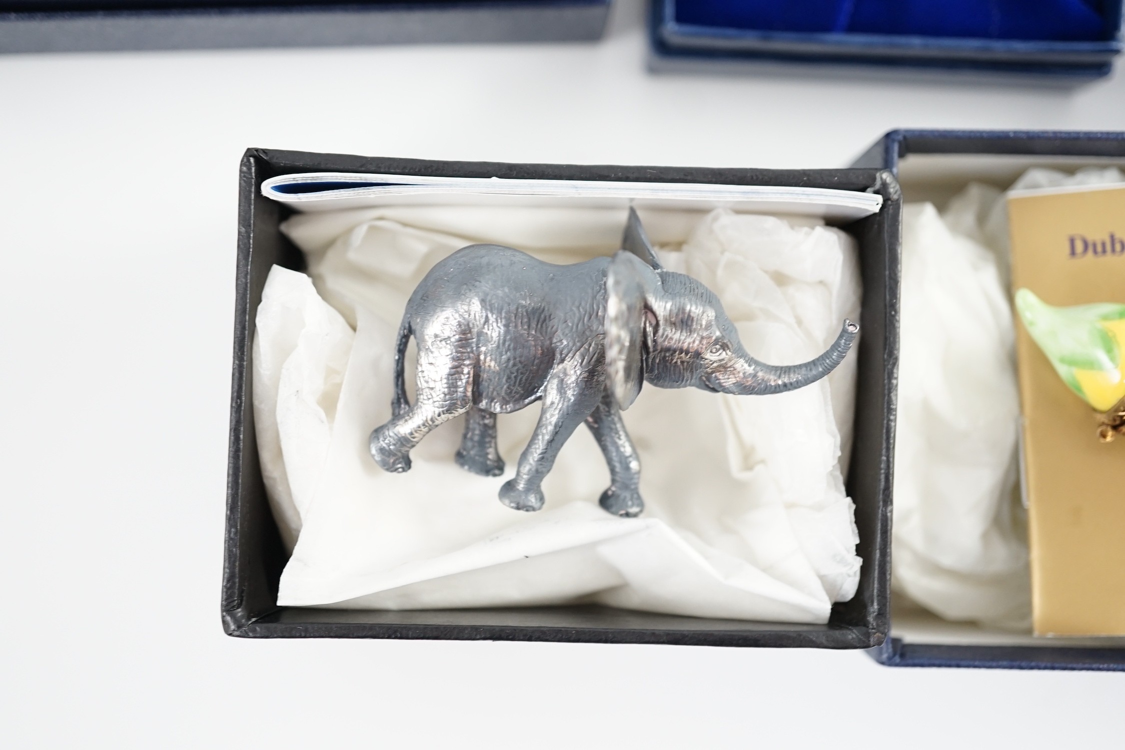 Two Halcyon Days enamel boxes; frog and 1991, two Dubarry boxes and a white metal model elephant, all boxed.